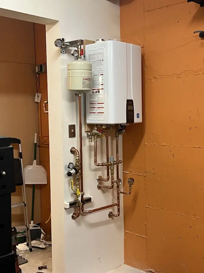 Plumbing technician inspecting water heater connections in Allegheny